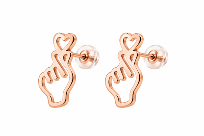 A pair of rose gold stud earrings featuring an outline of a hand with a heart symbol above it, shown on a plain white background.