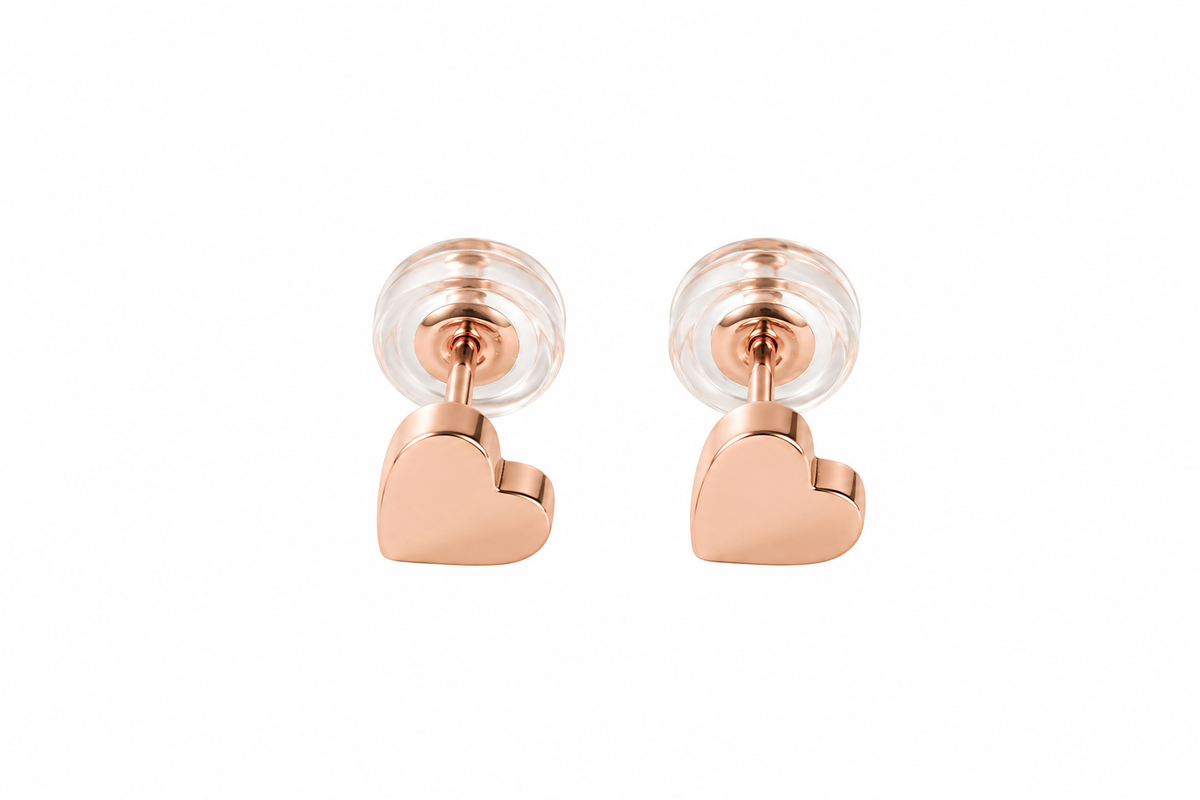 A pair of rose gold-tone heart stud earrings with clear backings, shown from the side on a white background.